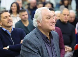 Лафчис: АЕК е по-силен, но Левски има шанс – важно е да не се уплаши Older man with white hair wearing a gray blazer sits in a crowded audience at a talk or event, looking ahead thoughtfully.