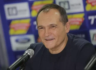 Божков: Вече не си искам парите от Левски, ще изчакам клубът да се стабилизира Middle-aged man in a dark shirt speaks into a microphone at a press event, logos blurred in the background.
