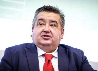 Караиванов потвърди: Левски – ЦСКА за Суперкупата остава на 9 септември Man in a navy suit with a red tie speaking at a panel or press event, looking to the side.