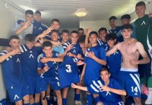 Левски U16 разгроми Етър Group of teenage soccer players in blue uniforms posing together in a locker room, some making hand signs, arms around each other in celebration.