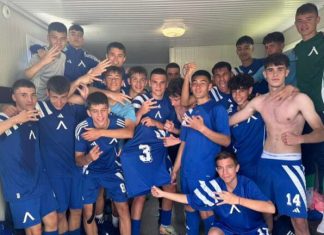 Левски U16 разгроми Етър Group of teenage soccer players in blue uniforms posing together in a locker room, some making hand signs, arms around each other in celebration.