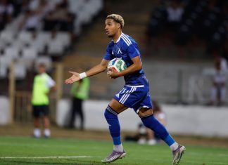 Око-Флекс след успеха над Славия: Искам да влизам и да променям мача Rugby player in a blue kit runs with a rugby ball tucked under his left arm on a grassy field during a match.