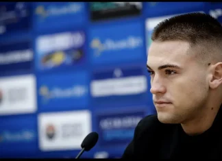 Виктор Викторов с емоционално послание: Заедно Левски е най-силен Portrait of a young man at a press conference, facing right, microphone in the foreground, blue backdrop with logos behind him.