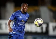 Алдаир – пълен профил и професионален път Male soccer player in a blue kit chasing a colorful ball on a field during a night match, focused and athletic posture.