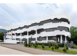 БФС наложи солени глоби след 11-ия кръг Modern white multi-story building with a curved, layered exterior and columns, surrounded by trees and a paved area.