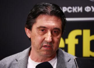 Боримиров след жребия с Лудогорец: Левски има шанс за реванш пред своите фенове Middle-aged man in a gray blazer and white shirt speaks into a handheld microphone at a press event, with a dark backdrop and partial yellow text in the background.
