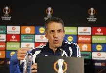 Бранител може да остане извън групата за Черно море Man in a navy jacket speaks at a press conference, seated behind a table with a microphone and a colorful sponsor backdrop behind him.