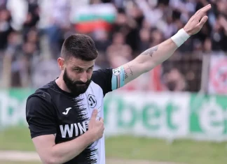 Димитър Илиев посочи фаворита за титлата Football player with black-and-white jersey raising his right arm in a stadium, crowd blurred in the background.