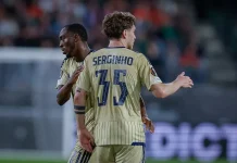 Два белгийски гранда следят халф на Левски Two soccer players in beige kits embrace on the field after a moment in the match, one showing the back with 'SERGINHO' and the number 17.