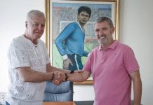 Емилио Ларас разкри как Веласкес го е довел в Левски и какво променя в школата на „сините“ Two men shake hands in an office, standing in front of a framed painting.