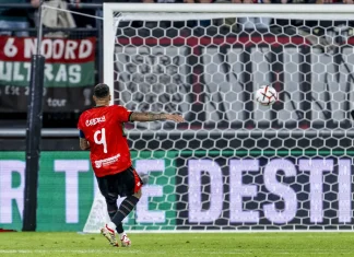 Голмайсторът за НЕК: Вратарят на Левски ми даде добро подаване Soccer player in a red jersey number 9 takes a shot toward the goal as the ball is in the air near the net.
