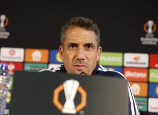 Хулио Веласкес е най-скъпоплатеният треньор в Първа лига Sports coach at a press conference speaking into a microphone, backdrop with sponsor boards and a trophy logo on the podium