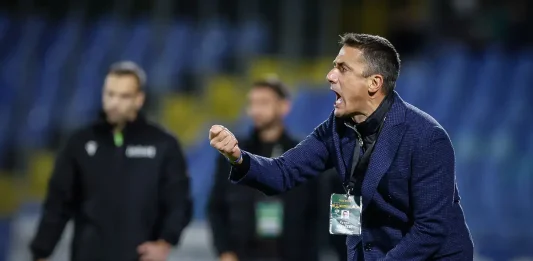 Хулио Веласкес вдигна жълт картон на двама в Левски Coach in a navy blazer shouting and gesturing on the sideline during a game, badge hanging from his neck.