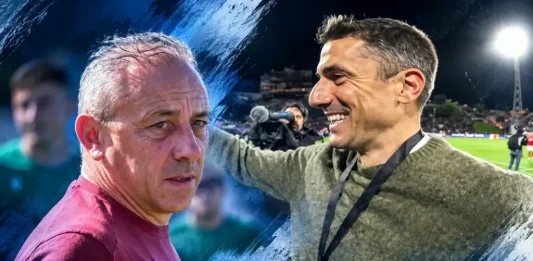 Илиан Илиев срещу Хулио Веласкес Two men on a football field share a moment, one in maroon shirt looking serious while the other smiles with a medal on a lanyard beside him, under stadium lights.