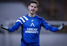 Илиян Стефанов кариера, статистика и факти Male soccer goalkeeper in a blue jersey with white stripes, arms outstretched on the field.