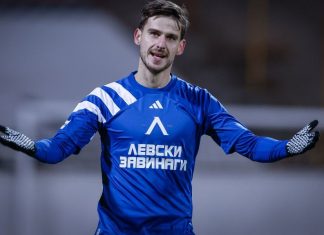 Илиян Стефанов кариера, статистика и факти Male soccer goalkeeper in a blue jersey with white stripes, arms outstretched on the field.