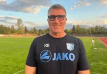 Красимир Бислимов след загубата от Левски: Затруднихме ги максимално, гордея се с момчетата Smiling man in a black JAKO jersey on a soccer field with a track in the background and trees beyond.