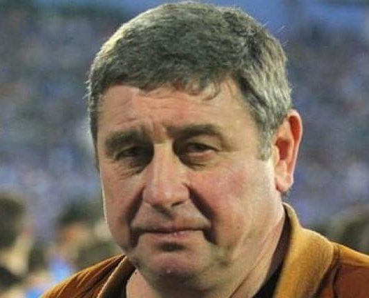 Легендата на Левски Мишо Вълчев на 70 Close-up of a middle-aged man with short gray hair wearing an orange jacket at a crowded event.