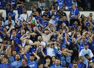 Левскарите изкупиха всички билети за гостуването на Черно море Huge crowd of blue-clad sports fans cheering in a stadium; a shirtless man with arms raised at center.