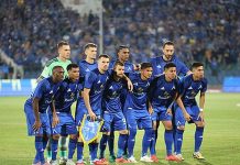 Левски чака нов човек от Серия А! Филаделфо Апаро се сбогува с Комо A soccer team in blue uniforms posing for a group photo on the field with a crowd in the stands behind them.