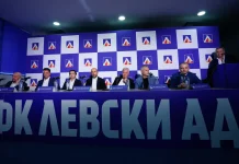 Левски готви нов удар! Преговаря с още един чужденец Panel of seven men seated at a press conference table with microphones in front of a blue checkered backdrop featuring a logo and large Cyrillic lettering in the foreground.