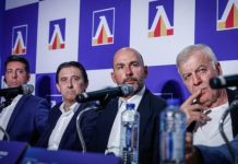 Левски се готви за преговори за подновяване на договорите на основни играчи Four men in suits sit at a press conference panel with microphones and a branded blue backdrop behind them.