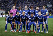Левски избра маршрут през Германия за гостуването на НЕК Group of soccer players in blue kits posing for a team photo on the pitch with a packed stadium in the background; pink-clad goalkeeper stands at the back left.