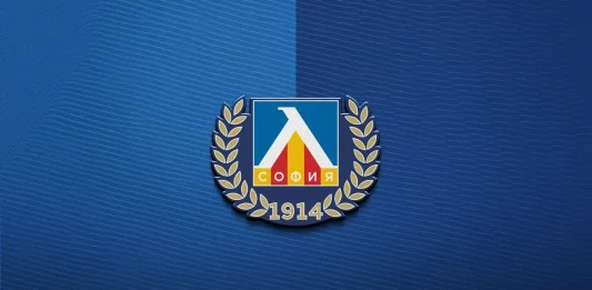 Левски надъха феновете си за гостуването в Ловеч с любопитно видео и музикален поздрав Emblem with a blue shield, white triangular arch, red and yellow bars, flanked by gold laurel branches, and ‘1914’ beneath on a blue textured background, resembling a union logo