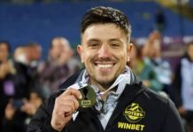 Левски с нов скаут Smiling man holding a gold medal labeled 2024 after winning a competition, wearing a jacket with WINBET logo.