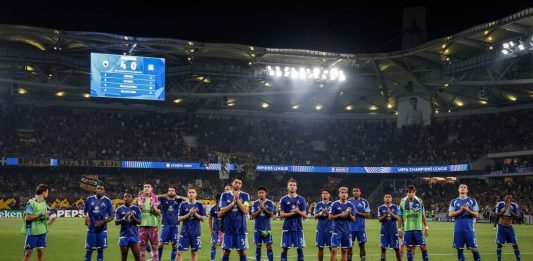Левски пише история в Европа! „Сините“ гонят рекорд на Лудогорец Soccer team in blue uniforms lined up on the grass field after a match in a large stadium, fans in the stands applauding.