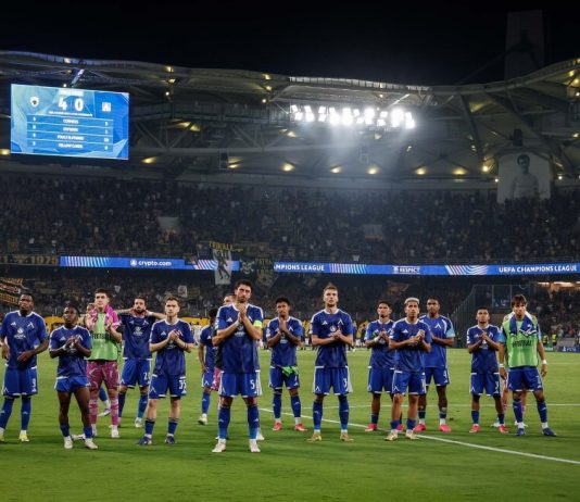 Левски пише история в Европа! „Сините“ гонят рекорд на Лудогорец Soccer team in blue uniforms lined up on the grass field after a match in a large stadium, fans in the stands applauding.