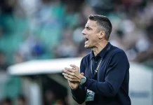 Левски пред раздяла с бразилец: Веласкес го остави извън сметките си Coach in a navy polo shouting and clapping on the sidelines during a game, wearing a lanyard and watch against a blurred crowd backdrop.