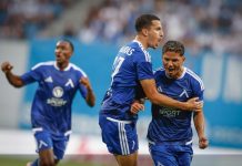Левски преследва първи точки и исторически пробив срещу НЕК Three soccer players in blue uniforms celebrate on the field, embracing and cheering.
