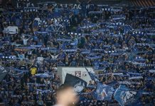 Левски пуска заявки за билети за гостуването на НЕК Large crowd of football fans in blue, waving scarves and banners in stadium stands in support of their team.