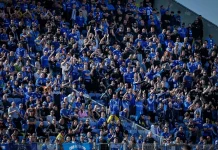Левски пусна билетите за „Тича“ Large crowd of sports fans in blue, seated in a stadium, many clapping and cheering.