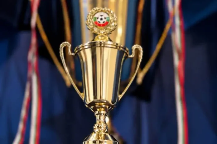 Gold trophy with ornate handles and a circular crest at the top.