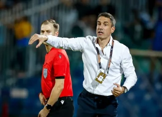 Левски се превърна в най-силния период в кариерата на Хулио Веласкес Soccer coach in a white shirt on the sideline, gesturing with his arm while a referee in red stands nearby during a match.
