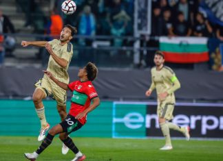 Левски ще преговаря с халф за нов договор Two players jump to head the ball during a soccer match, one in beige and the other in red and black.