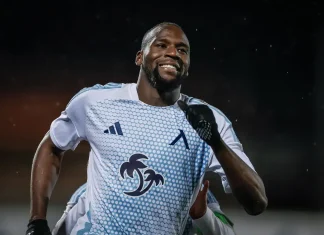 Левски си отдъхна за Сангаре Soccer player in a light blue jersey celebrates with a smile, running on the field at night.