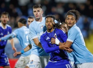 Левски се спаси от загуба срещу Арда Three soccer players battle for the ball: two in light-blue jerseys brace a purple-clad player as they contest near the goal area.