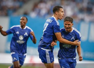Левски стигна до паузата с първи сигнали за умора Two soccer players in blue jerseys celebrate a goal on the field, one hugging the other as a teammate erupts in celebration in the background.