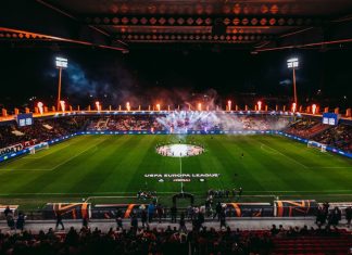 Левски с важни указания към феновете преди мача с Виктория Пилзен Nighttime UEFA Europa League stadium celebration: circular center-circle display with players around the emblem, flames and smoke in stands, full stands.