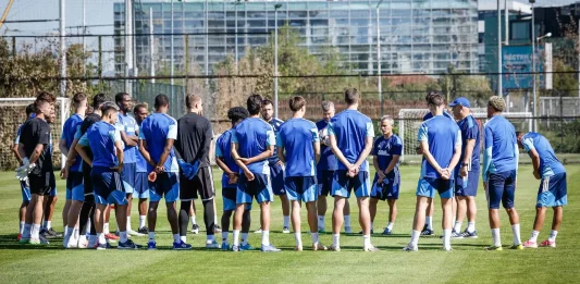 Левски влиза в подготовка за Черно море Soccer players in blue training kits stand in a circle on a green grass field during practice with a goal in the background.