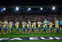 Левски впечатлява с дисциплина в Европа: само 15 жълти картона в 11 мача Soccer players lined up with young mascots on the field before a match, stadium filled with fans in the background.