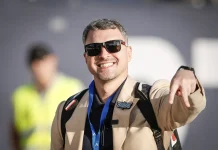 Левски взима специалист от Комо! Валери Божинов мечтае за „син“ Галактикос Smiling man in sunglasses and a tan jacket with a blue lanyard, pointing at the camera.