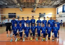 Левски започна с чиста победа на турнира във Флорина Volleyball team in blue uniforms posing for a group photo on an indoor court with a net behind them.