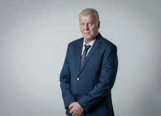 Наско Сираков е наказвал Спартак Плевен във финал Older man in a navy suit and striped tie posing against a light gray studio backdrop, hands clasped in front.