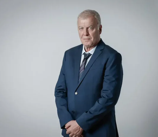Наско Сираков е наказвал Спартак Плевен във финал Older man in a navy suit and striped tie posing against a light gray studio backdrop, hands clasped in front.