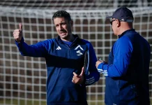 Още един испанец влиза в щаба на Хулио Веласкес Coach gives a thumbs-up while talking to a teammate on a soccer field, goal net in the background.