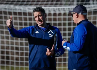 Още един испанец влиза в щаба на Хулио Веласкес Coach gives a thumbs-up while talking to a teammate on a soccer field, goal net in the background.